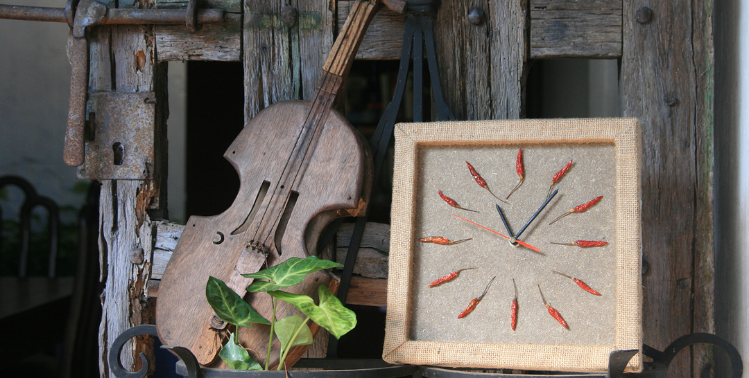Rustic paper clock with chili pepper markers and wooden violin, showcasing Historia Rodziny PUC handcrafted art.